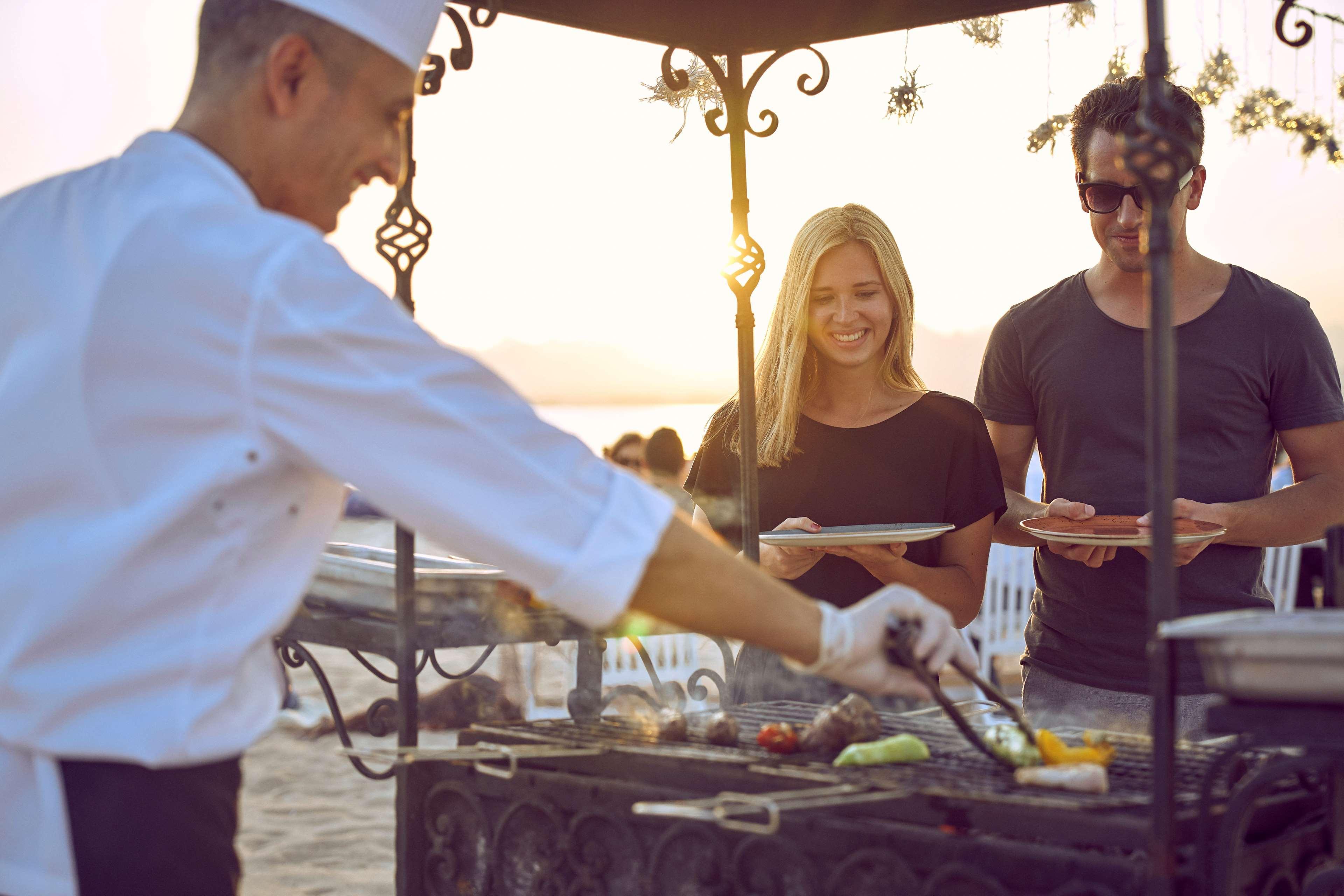 Kempinski Hotel Soma Bay Esterno foto A chef serving food at a buffet